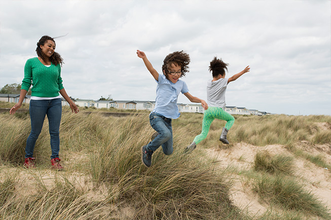 kids jumping in sand dunes